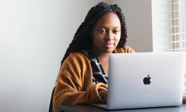 Image of a woman working on a laptop.